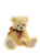 A pale yellow fluffy teddy bear sits upright against a white background, wearing a bronze satin bow tie with a small silver heart charm.