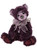 A deep purple/plum Charlie Bear sits upright, adorned with a grey organza bow, lace collar, and a silver heart-and-padlock charm pendant. Paws feature dark burgundy suede pads.