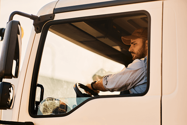 Truck Driver Sitting in the Cab of an International Truck, Focused on the Road