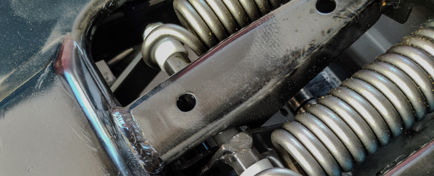 Close-up of semi-truck suspension seat springs and mounting bracket.