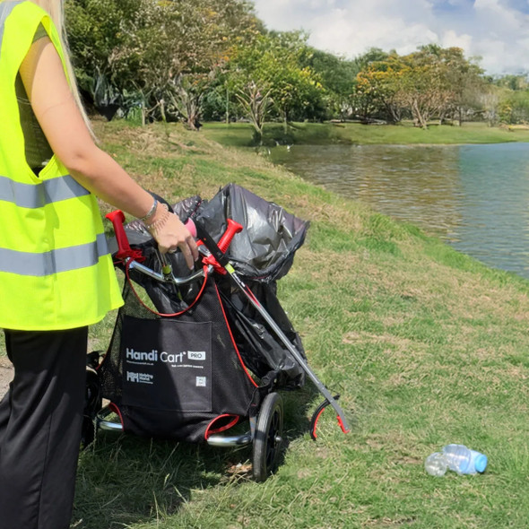 Close-up of person wearing high-vis vest collecting litter with a picker and the Handicart Pro Trolley