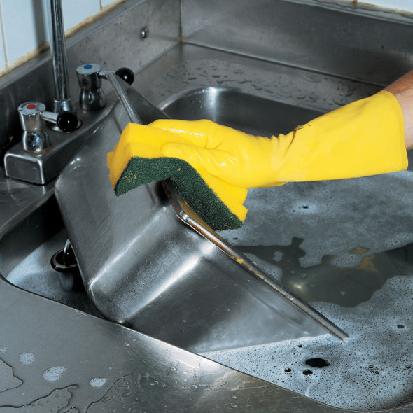 User wearing a yellow rubber glove washes a stainless steel gastronorm pan using an Astree 21 Ergonomic Scouring Sponge