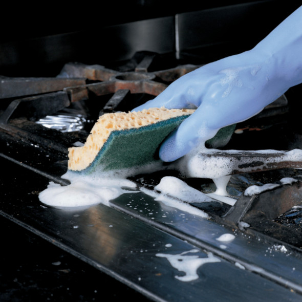 Person wearing blue gloves using a Sponrex 52 Small Sponge Scourer to clean gas cooker hobs