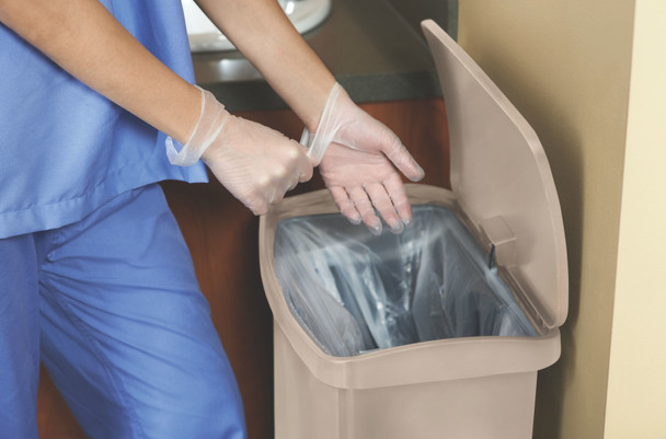 1883458 - Hospital worker removes a pair of clear latex gloves