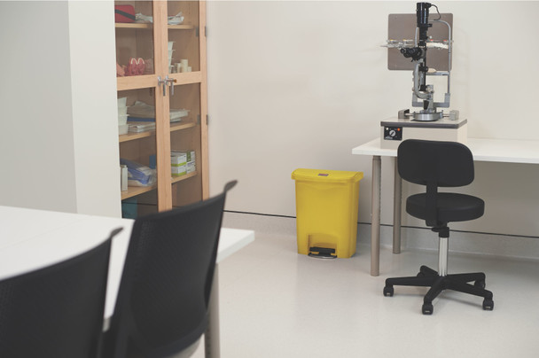 1883573 - A yellow Rubbermaid Slim Jim Front Step Pedal Bin situated in a medical lab