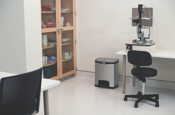 1901985 - A stainless steel Rubbermaid Slim Jim Front Step Pedal Bin situated in a medical examination room