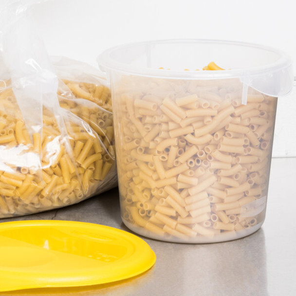 Container Placed on Worktop Next to a Yellow Lid and Filled with Pasta