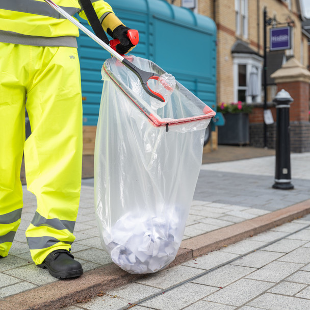 A Street Cleaner Uses the Streetmaster Pro to Place Litter in A Clear Bin Bag that is Attached to Handi-Hoop