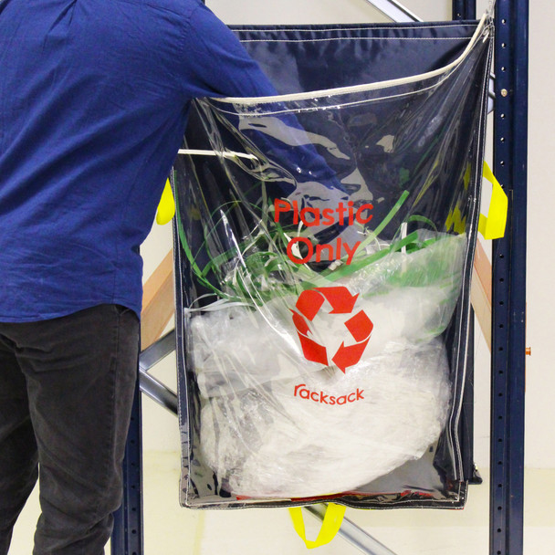 Warehouse Worker Placing Plastic Waste in a Plastics Racksack