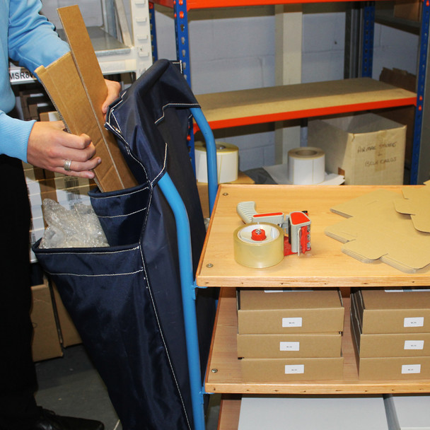 Racksack 2-Pocket Reusable Recycling Sack Hung from the Handle of a Trolley Being Used for Packing
