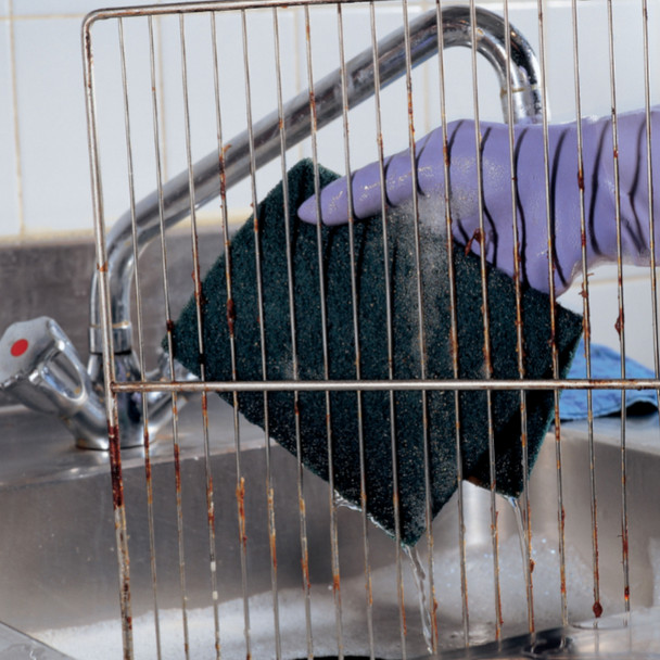 A Mercury 44 Large Green Scouring Pad being used to clean an oven shelf by someone wearing a purple rubber glove