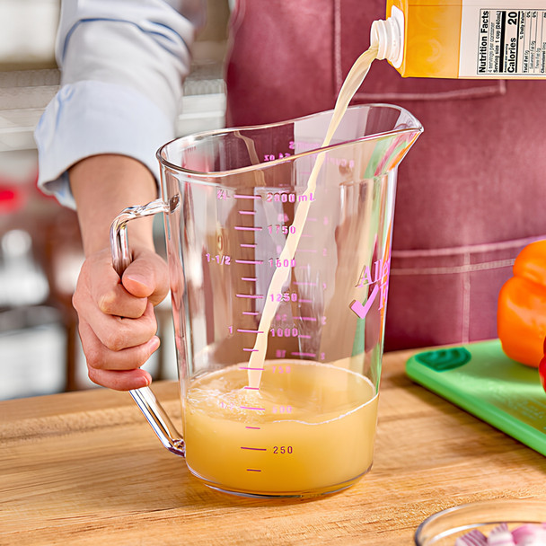 User filling a 2 litre Cambro Allergen-Safe Measuring Jug with fruit juice