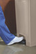 1883458 - Close-up of a hospital worker dressed in blue scrubs and wearing white trainers pressing foot pedal