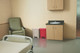 1883564 - A beige and red Rubbermaid Slim Jim Front Step Pedal Bin situated in hospital a room