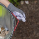 Gloved User Pulls at Bungee Cord to Show It Holding a Liner in Place
