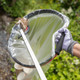 A Gloved User Drops Brown Paper into a Liner Attached to a Handi-Hoop