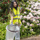 Close-Up of A Female Wearing High-Vis Vest, Gloves and Using a Litter Picker Placing Rubbish into a Liner that is Attached to a Handi-Hoop