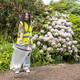 A Female Wearing High-Vis Vest, Gloves and Using a Litter Picker Places Rubbish into a Liner that is Attached to a Handi-Hoop