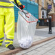A Street Cleaner Uses the Streetmaster Pro to Place Litter in A Clear Bin Bag that is Attached to Handi-Hoop
