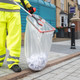 A Street Cleaner Uses the Streetmaster Pro to Place Litter in A Clear Bin Bag that is Attached to Handi-Hoop