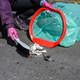 A gloved handi-hoop user utilises the innovative rim to sweep waste into the bin bag