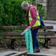 A lady wearing a hi-vis vest holds the handi-hoop fitted with green liner in one hand and a litter picker in the other