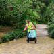 A lady wearing a high-vis vest using the Handicart Lite to collect litter from a footpath
