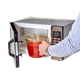 1.9L Cambro High Heat Measuring Jug Filled with Passate Being Removed from Microwave