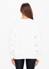 THE UPSIDE women's white Saturn Arrow Sweater is an organic cotton fleece jumper with a relaxed, oversized fit. It features a soft rib at the neckline, handcuffs and cuffs.