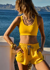 THE UPSIDE women's yellow Dunes Jade Racerback Bra is made from recycled textured rib fabrication with moisture wicking properties. The full coverage bra has a scooped T bar back, internal underbust elastic and removable cups . Designed for the gym.