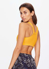 THE UPSIDE women's yellow Dunes Jade Racerback Bra is made from recycled textured rib fabrication with moisture wicking properties. The full coverage bra has a scooped T bar back, internal underbust elastic and removable cups . Designed for the gym.