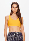THE UPSIDE women's yellow Dunes Jade Racerback Bra is made from recycled textured rib fabrication with moisture wicking properties. The full coverage bra has a scooped T bar back, internal underbust elastic and removable cups . Designed for the gym.
