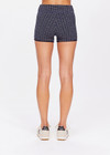 THE UPSIDE women's navy Caleta 3 inch Spin Short is made with gold lurex, a speciality fabric. The mid rise spin short is framed in navy ribbed binds with a speciality curved leg line. Designed for yoga, pilates and walking.