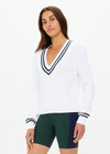 THE UPSIDE women's white Sonny V Neck Knit Sweater is made from organic cotton. The classic V neck knit features a navy and green stripe at the neck and sleeve for an elevated finish. Designed for leisure and recovery.