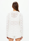 THE UPSIDE women's white Lavalliere Malia Knit Shirt is made from organic cotton. The long sleeve knit shirt features an open lace knit construction with bow knitted detailing and fitted with buttons and a ribbed collar. Designed leisure and recovery.