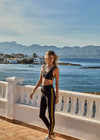 THE UPSIDE women's black Beaufort 25 inch Midi Pant is made from recycled soft peached fabrication with a brushed handfeel for a breathable and quick drying effect. The mid rise pant features an elasticated drawcord for the perfect fit and yellow stripes down the side for style. Designed for the gym and running.