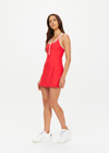 THE UPSIDE women's red Pacific Ali Racer Back Dress is made from recycled peached. The scoop neck tennis dress features built in shorts with pockets. Designed for tennis and pickleball.