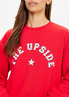 THE UPSIDE women's red Ranchero Saturn Crew Sweater is made from organic cotton. The oversized sweater features print western logo. Designed for lifestyle wear.