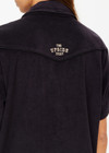 THE UPSIDE women's black Saddle Up Collared Hardy Shirt is made from hemp and cotton blend. The buttoned up shirt features pockets. Designed for comfort.