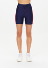 THE UPSIDE women's navy Oxford 5 inch Spin Short is made from eco tech performance fabric. The mid-rise bike short features red side stripes detailing. Designed for high impact workouts.