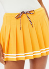 THE UPSIDE women's mimosa yellow recycled fabric Prix Quinny Pleated Skirt features a inner spin short with pockets and elasticated drawcord waist. Made for tennis.