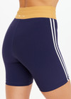 THE UPSIDE women's navy recycled peached Daytona 6 Inch Spin Short is designed for a mid-rise fit featuring contrast cream binds. Made for yoga & pilates.