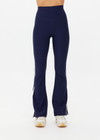 THE UPSIDE women's navy recycled peached Florence Flare Pant is a high-rise pant in a breathable fabric, featuring cream side stripes. Perfect for pilates.