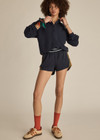 THE UPSIDE women's navy recycled fabric Starburst Lucky Run Short is designed for a true to size fit with invisible side zip pockets. Made for running.