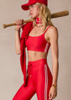 THE UPSIDE women's red eco tech Oxford Hutton Scoop Bra offers support and comfort with cream side stripes, adjustable straps, removable cups, and shelf bra. Made for high impact.