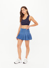 THE UPSIDE women’s blue denim Lykke Jaida Pleated Skirt, in a soft chambray fabrication, features an inner spin short with piping at the top edge. Made for tennis.