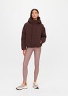 THE UPSIDE women's brown Mercer Hooded Puffer Jacket is fully lined and features invisible zip pockets with fleece lining, soft elasticated cuffs, a hood and is made from recycled fabric. Made for lifestyle.
