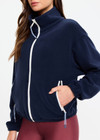 THE UPSIDE women’s navy recyled Sol Fleece Jacket offers a relaxed fit and features a zip through front, front zip pockets, elasticated waist and cuffs and contrast paracord zip pullers. Made for lifestyle.