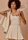 THE UPSIDE women’s cream recycled Kova Racerback Dress has built in shorts with pockets, a scooped front neckline with a racerback bra. Made for tennis.