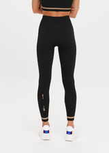 THE UPSIDE Form Seamless 25inch Midi Pant in Black is a solid knitted seamless mid-rise 7/8 length midi pant with contrasting classic sporty strips at cuff.